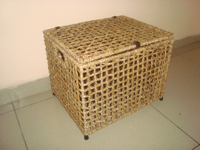 Cuboid shaped laundry basket made of wicker with a lid on top